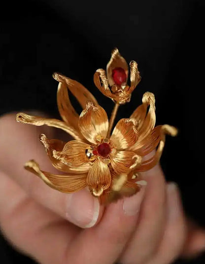 Model wearing a gold Chinese filigree pear blossom brooch, styled on a blazer lapel.