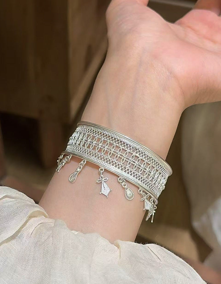Model wearing a pure silver filigree tassel bracelet, with tassels moving gracefully to highlight elegant oriental aesthetics