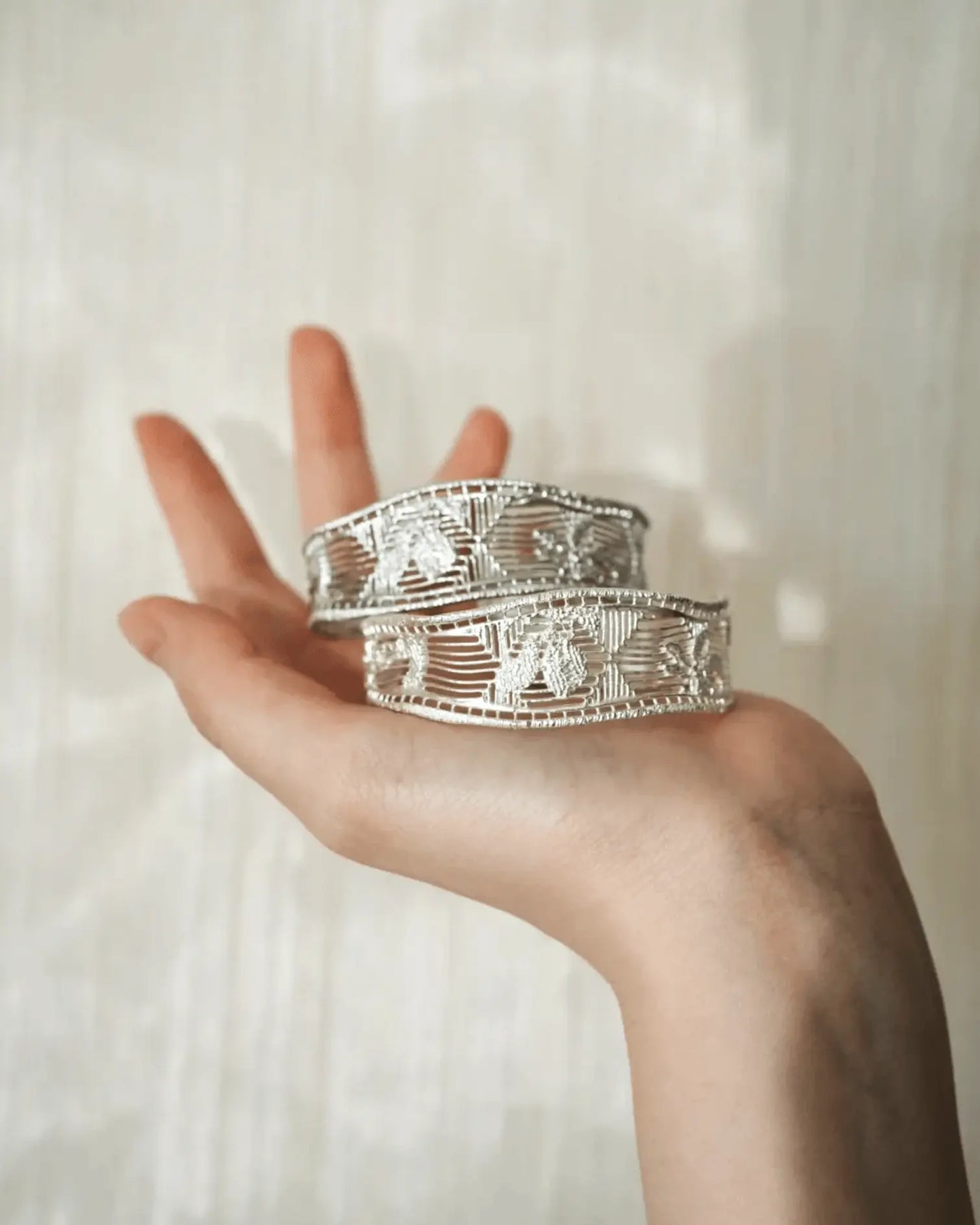 Close-up of hand-woven gardenia motif on crescent-shaped open bangle, blending traditional filigree with modern flow
