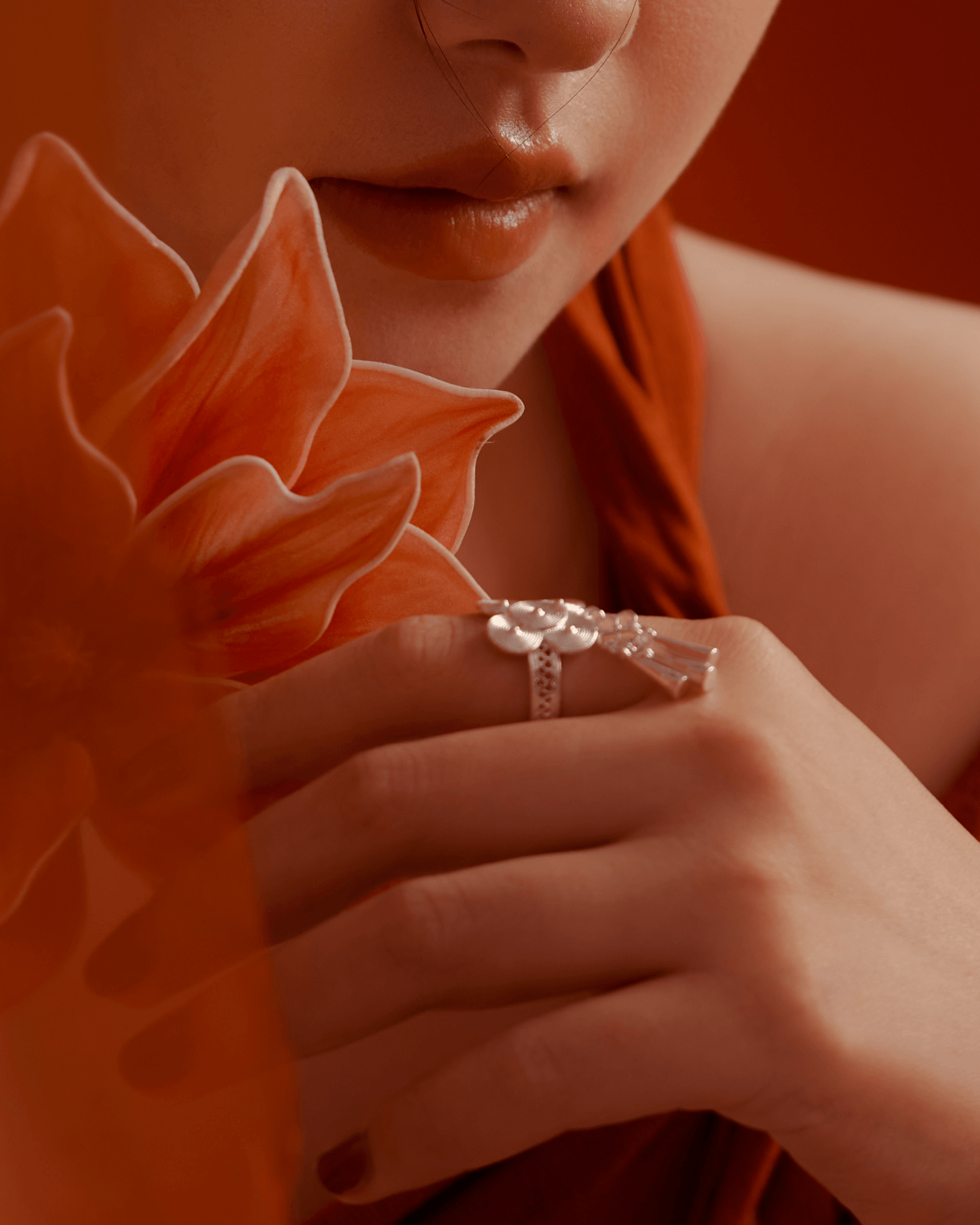 Close-up of ring on hand, silver bells gently hanging and catching light, conveying soft movement and ritual depth
