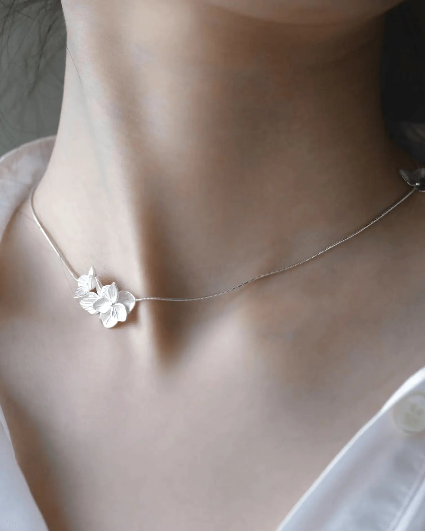 Model wearing silver petal necklace with Simple white shirt, capturing Eastern femininity and quiet sophistication
