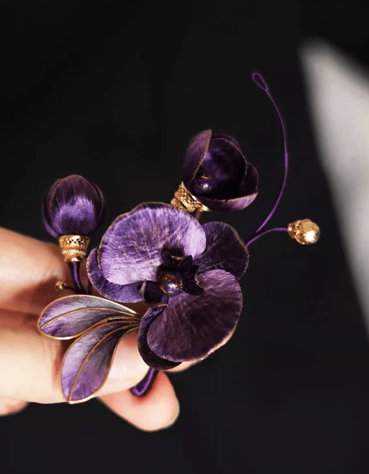 Vanda ‘Miss Joaquim’ Orchid brooch paired with evening gown, highlighting Chinese lacquer artistry and sophisticated purple elegance