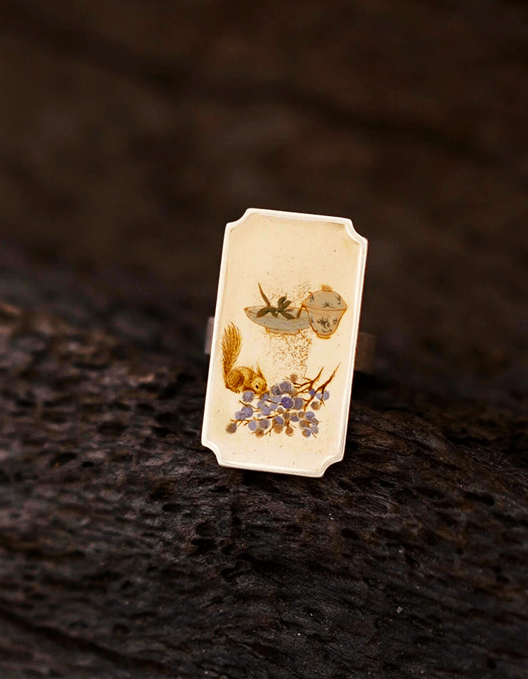 Detailed view of Chinese lacquer ring featuring miniature painting, lacquer finish, and silver setting