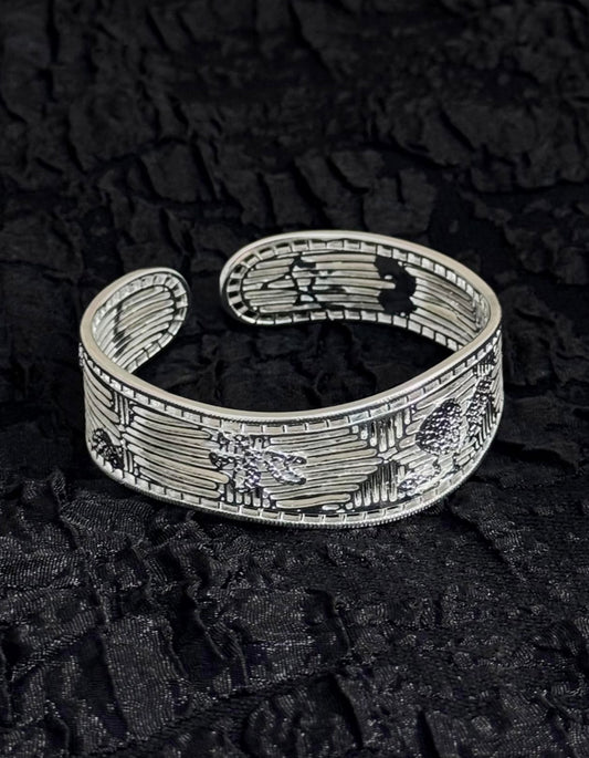 Flat lay of Flat lay of filigree silver bangle with gardenia petal openwork, inspired by Chinese heritage metalwork with gardenia petal openwork, inspired by Chinese heritage huasixiangqian metalwork