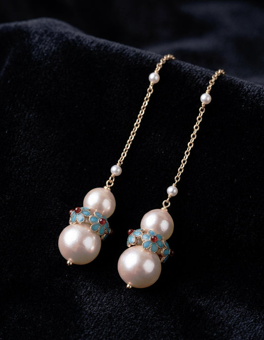 An artistic union of traditional Chinese Dian Lan enamel and organic cotton pearls. These lightweight drop earrings feature turquoise and crimson floral motifs.