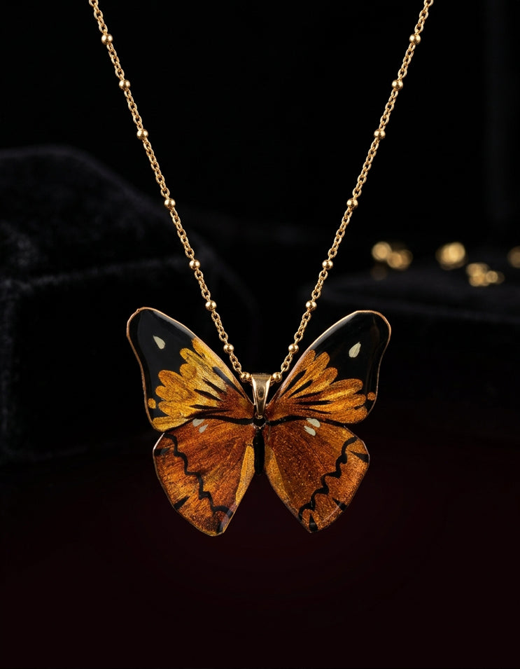 A lifelike butterfly rests at the collarbone in Zolan's hand-painted Chinese lacquer necklace. An artisanal, made-to-order piece shaped by time.