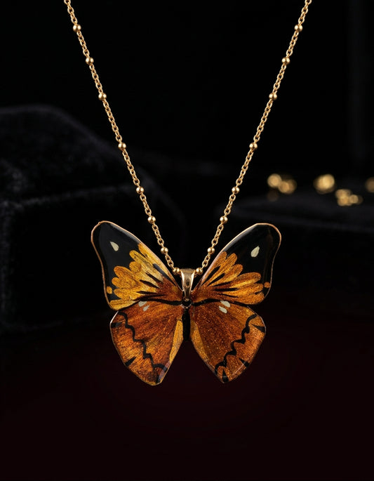 A lifelike butterfly rests at the collarbone in Zolan's hand-painted Chinese lacquer necklace. An artisanal, made-to-order piece shaped by time.