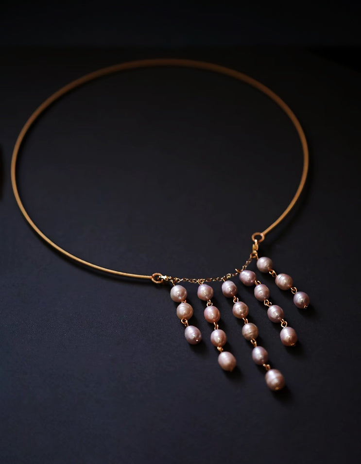 An architectural tassel necklace weaving rosé freshwater pearls. Handcrafted with fine sterling silver and rose gold links inspired by East Asian architecture.