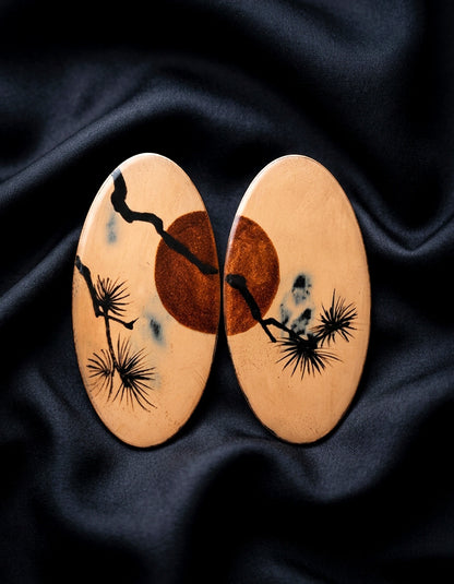 A miniature classical landscape. These artisan Chinese lacquer wood earrings pair a burnished bronze background with hand-painted pine & sunset motifs.