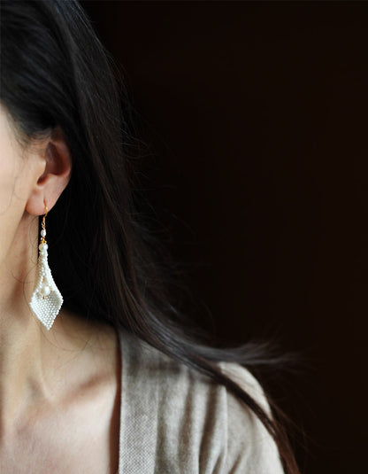 Model wearing ZolanJewelry handwoven calla lily pearl earrings, radiating elegance and grace.