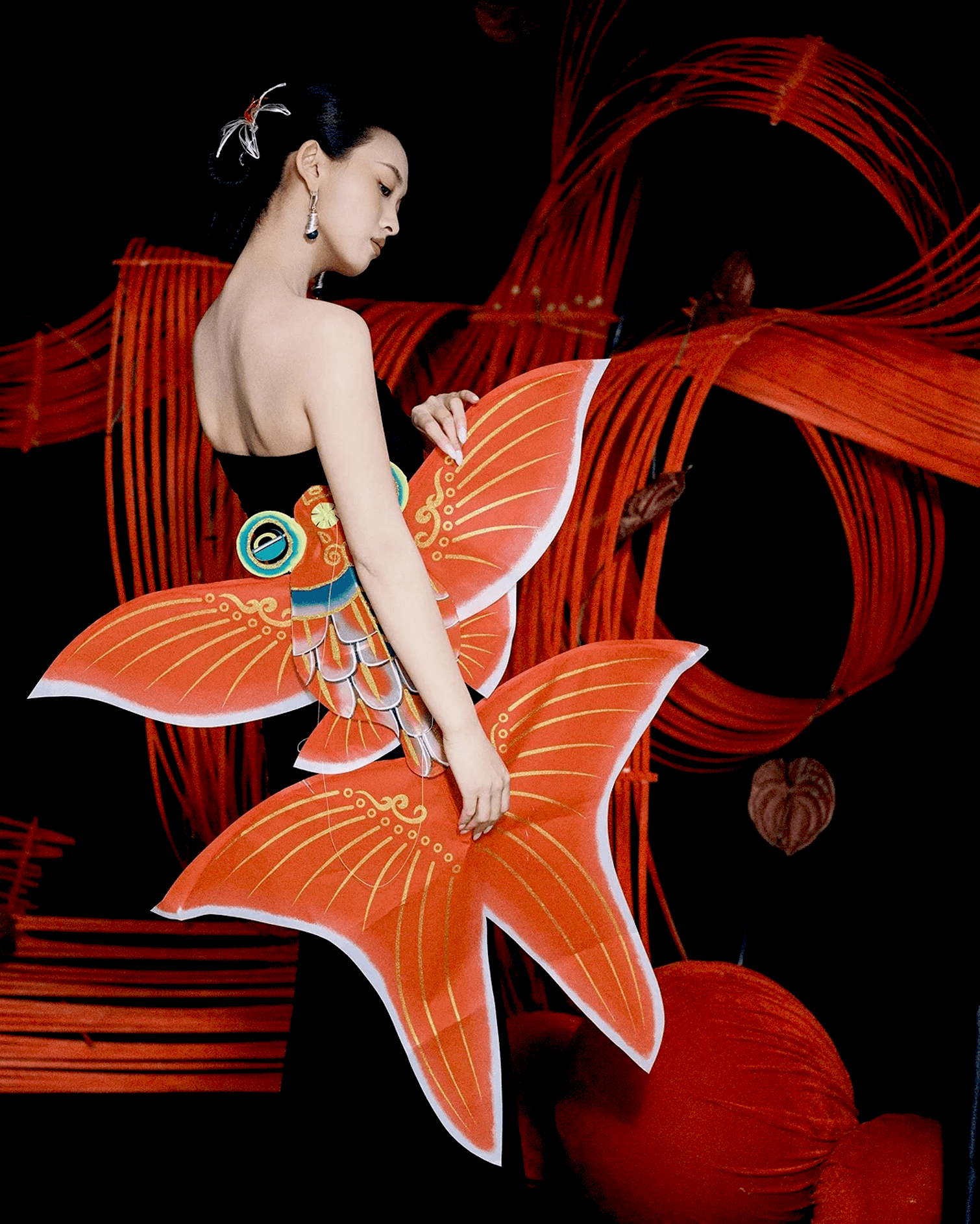 Model wearing celestial swirl earrings styled with architectural black dress, blending Eastern philosophy with avant-garde fashion
