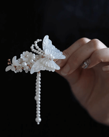 Flat lay of iridescent butterfly hair clip hand-carved from natural mother-of-pearl with silver tassels, inspired by Liang Shanbo and Zhu Yingtai legend