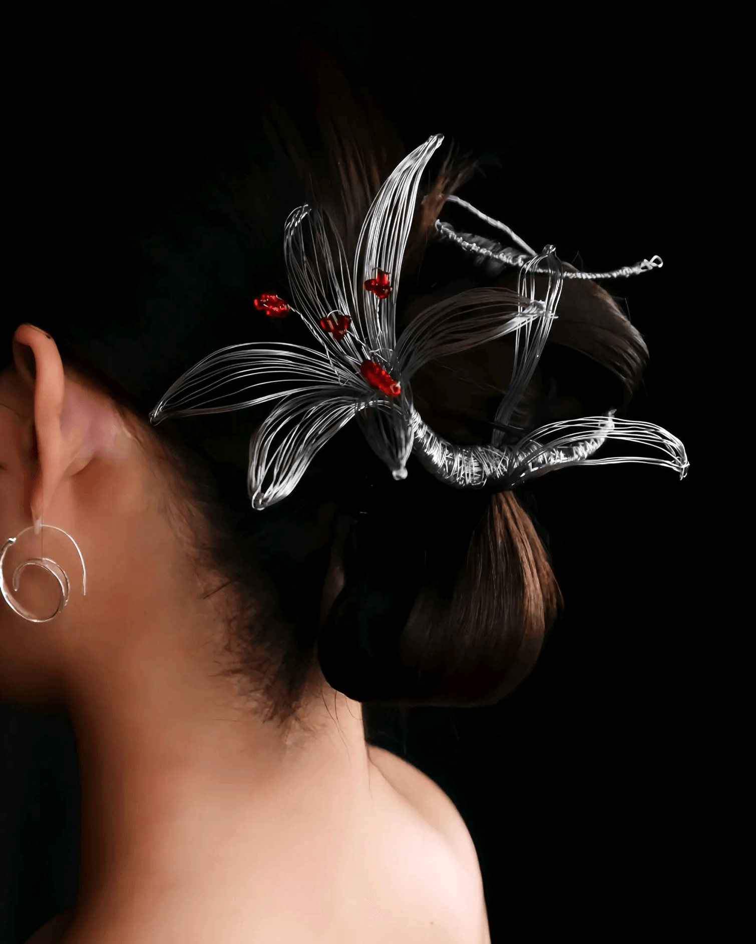 Close-up of hand-shaped 0.3mm silver-coated brass wire coiled into blooming lily petals