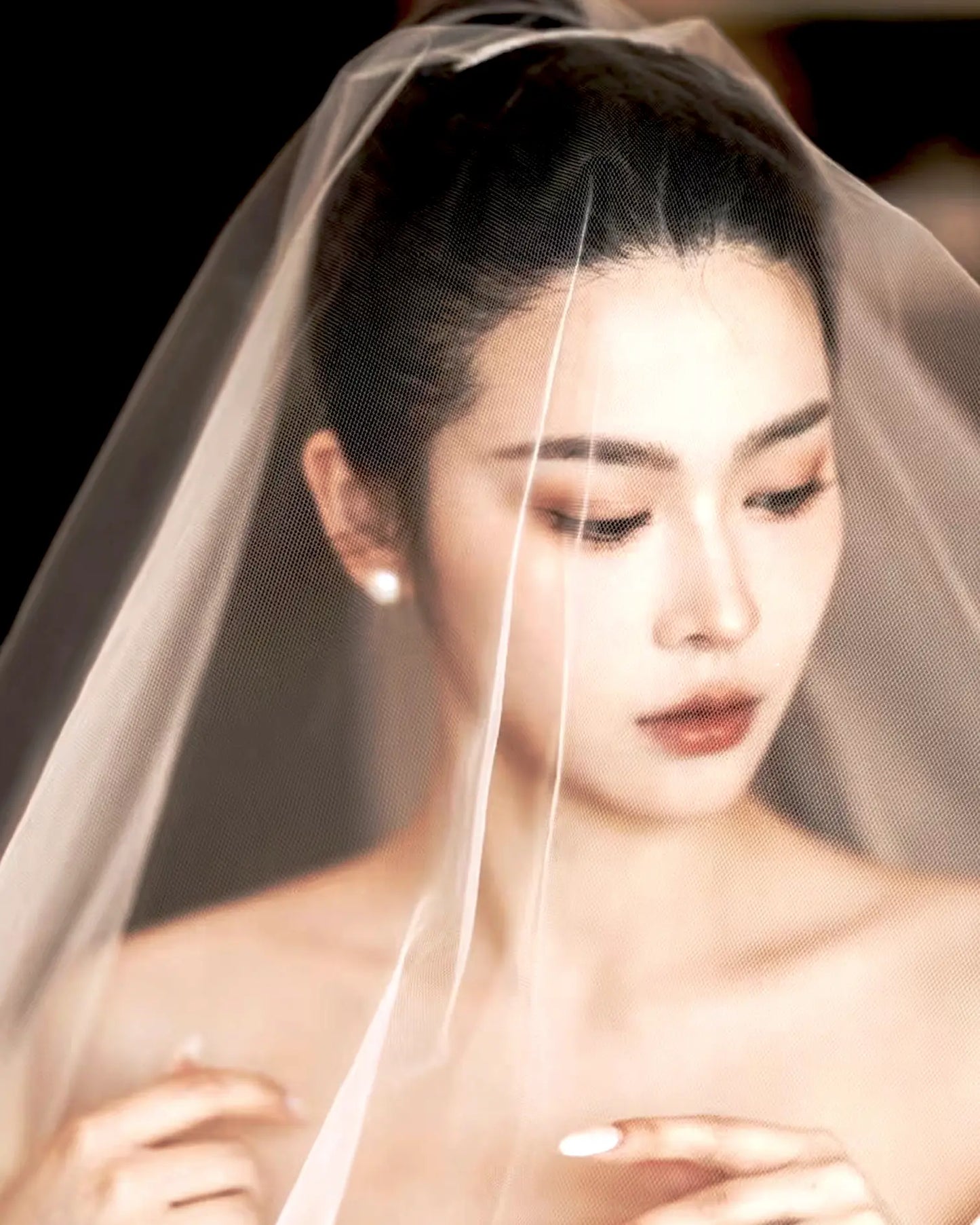 Side view of earrings on bridal hairstyle, glowing softly under natural light