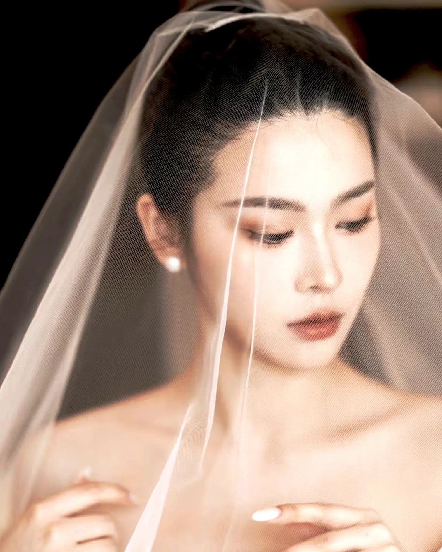 Side view of earrings on bridal hairstyle, glowing softly under natural light