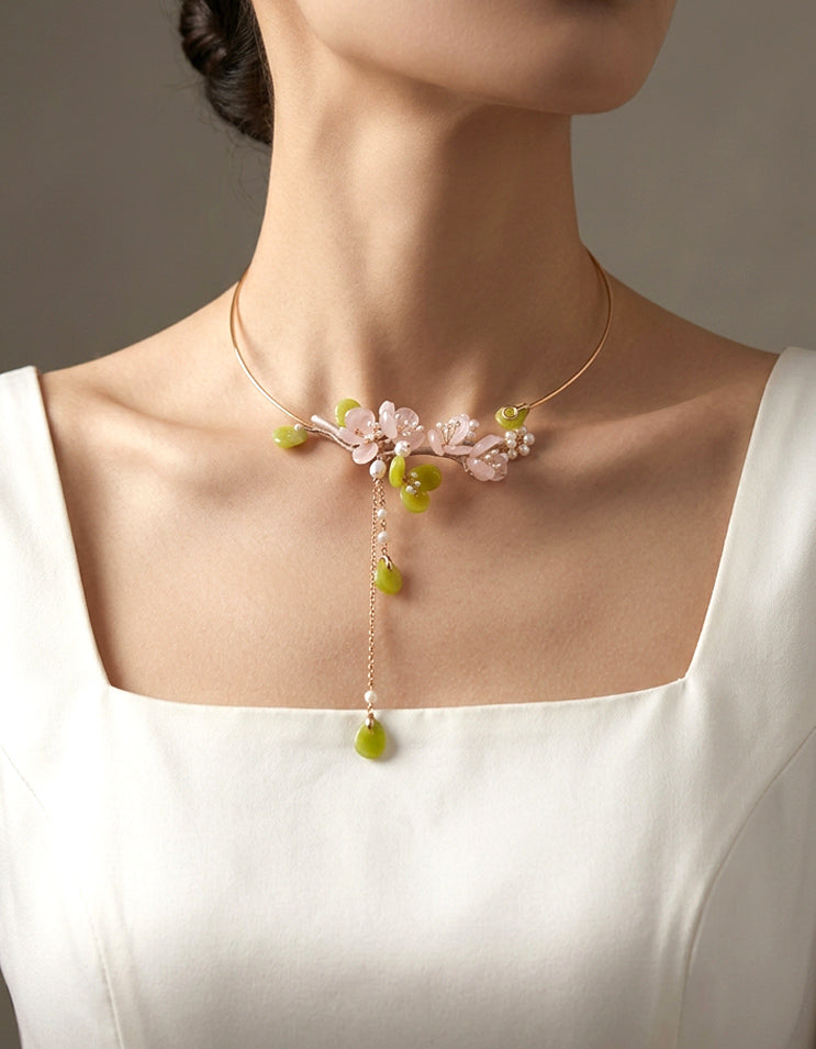 Hand-carved rose quartz plum blossom choker featuring soft blush tones. An elegant Chinese floral statement necklace for modern elegant styling.