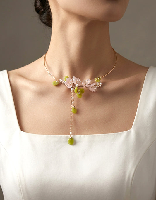 Hand-carved rose quartz plum blossom choker featuring soft blush tones. An elegant Chinese floral statement necklace for modern elegant styling.